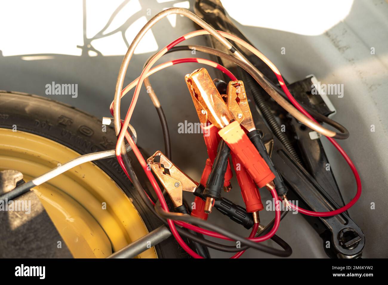 Batterie-Starthilfekabel mit Wagenheber und Werkzeugen im Kofferraum Stockfoto