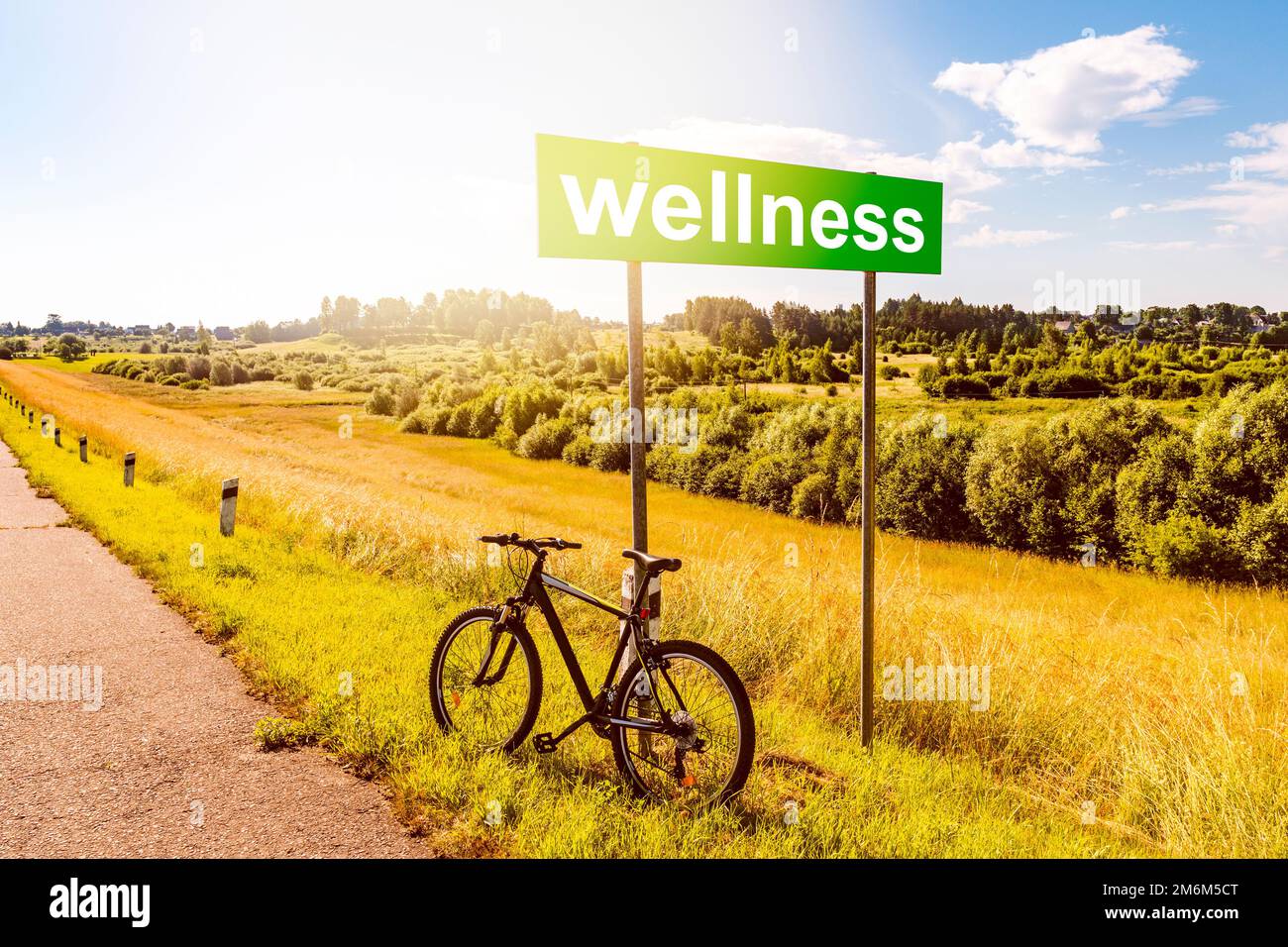 Sportfahrrad lehnt sich gegen Transportschild mit WELLNESSAUFDRUCK Stockfoto