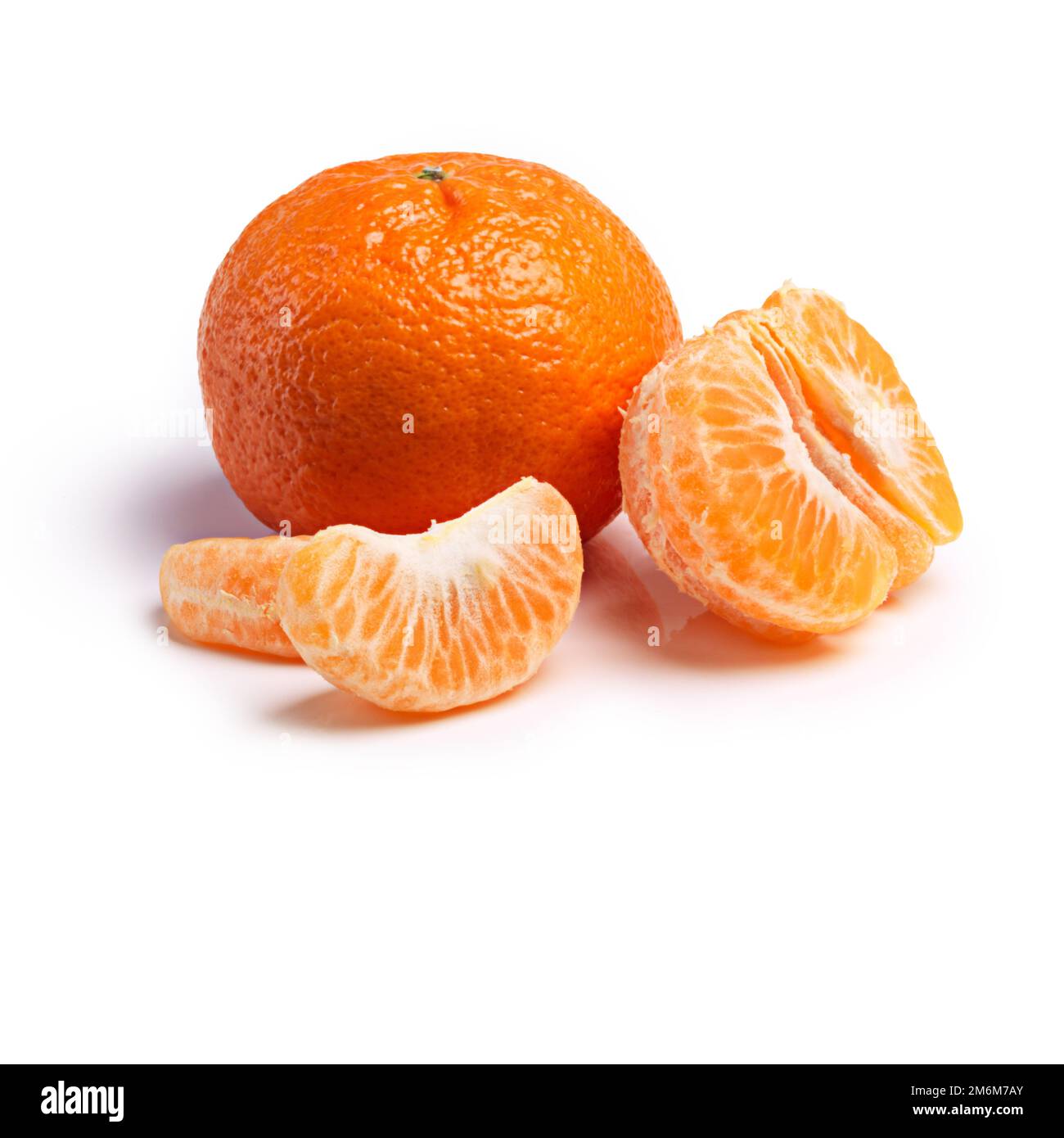 Genießen Sie den Geschmack. Ein Studiofoto mit Mandarinenscheiben neben einer ganzen Frucht. Stockfoto