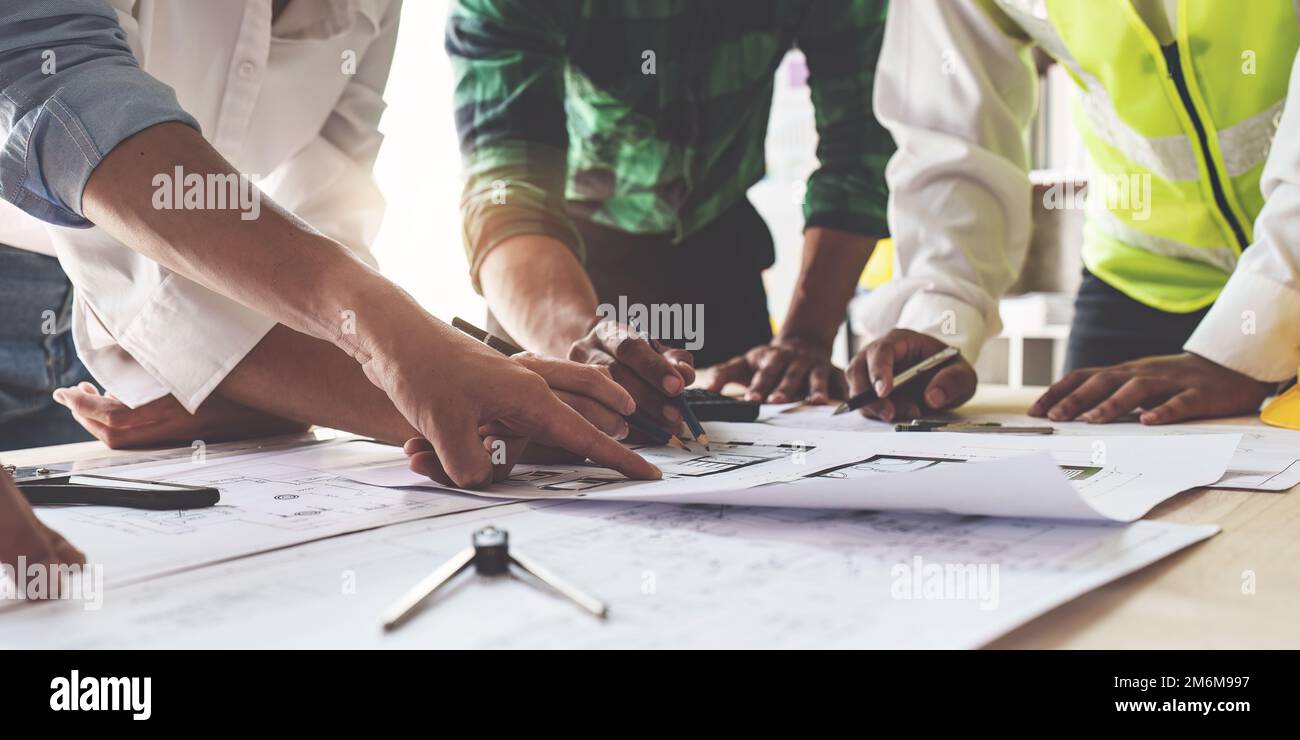 Architektenteam arbeitet mit Bauplänen für den Architekturplan, Ingenieur skizziert ein Bauprojekt, grünes Energiekonzept Stockfoto