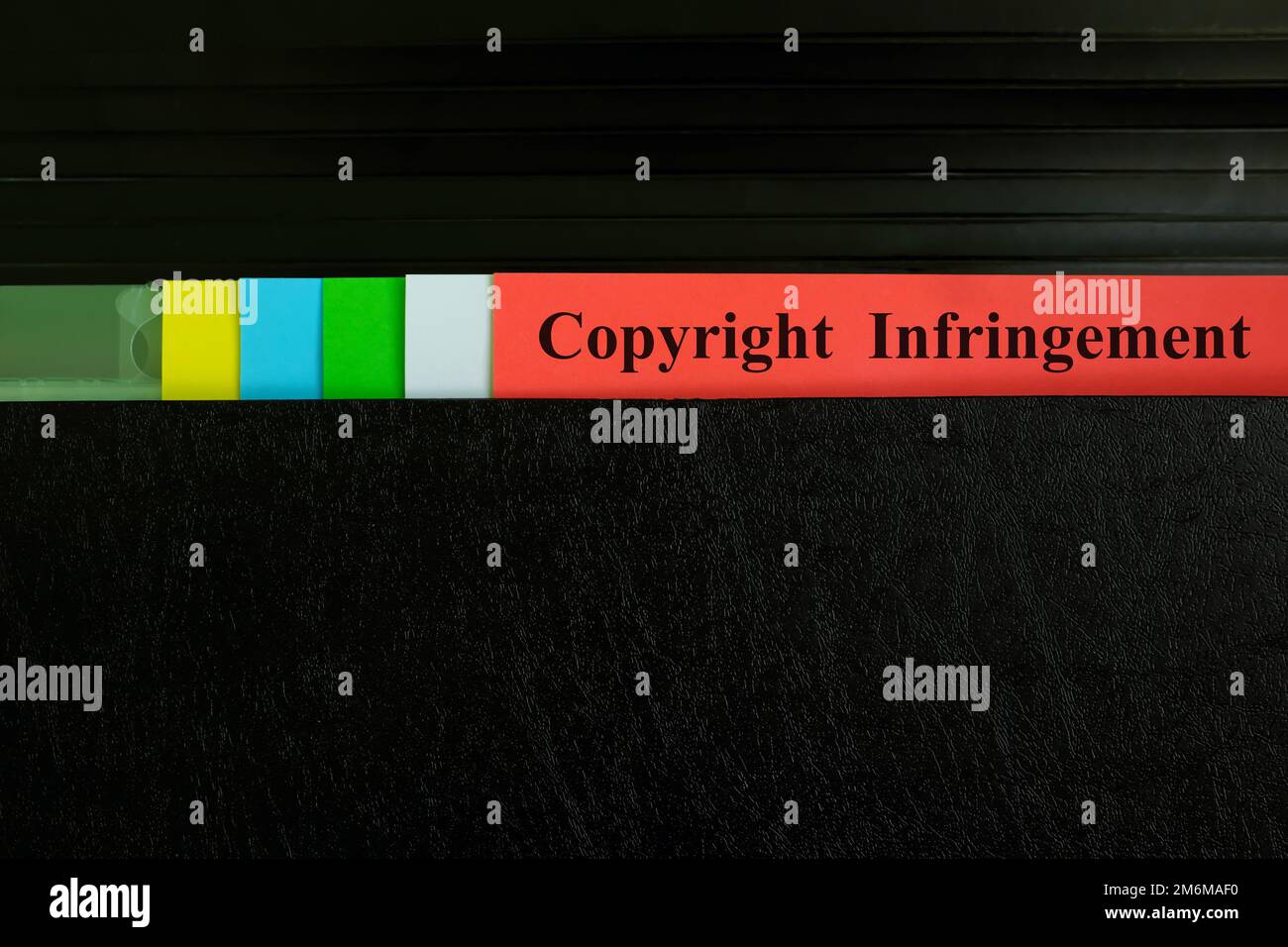Manuelle Auswahl des Datensatzes für Urheberrechtsverletzungen im schwarzen Ordner. Rechtsbegriff für Urheberrechtsverletzungen. Stockfoto