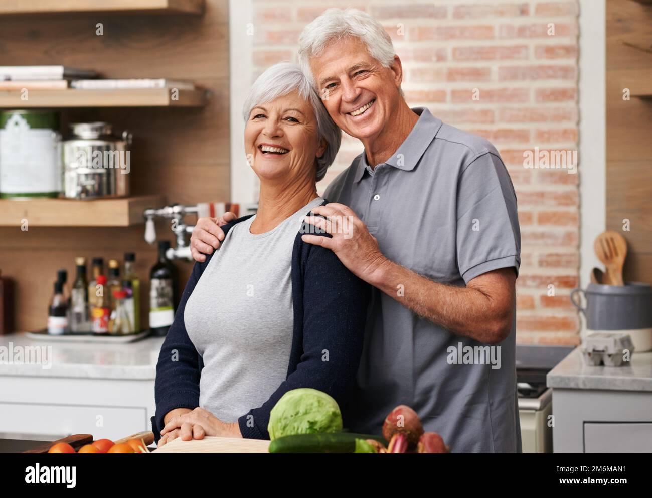 Heute bringe ich ihm das Kochen bei. Liebevolle Aufnahme eines Seniorenpaares, das in einer Küche posiert. Stockfoto