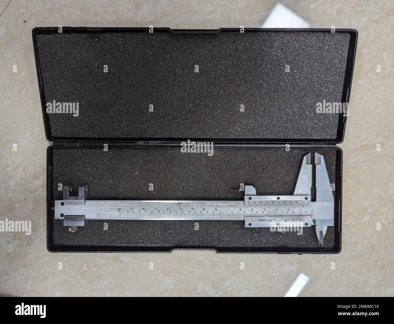 Ein brandneues analoges Messschiebermessgerät aus Edelstahl für Präzisionsmessungen in einem isolierten Kasten Stockfoto