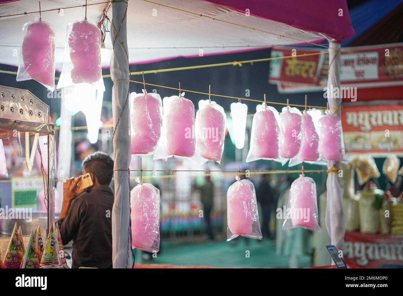 Leckere Zuckerwatte, die man auf dem indischen Vergnügungspark zum Verkauf aufhängen kann, leckere rosa Zuckerwatte, die auf dem indischen Markt des Vergnügungsparks verkauft wird Stockfoto