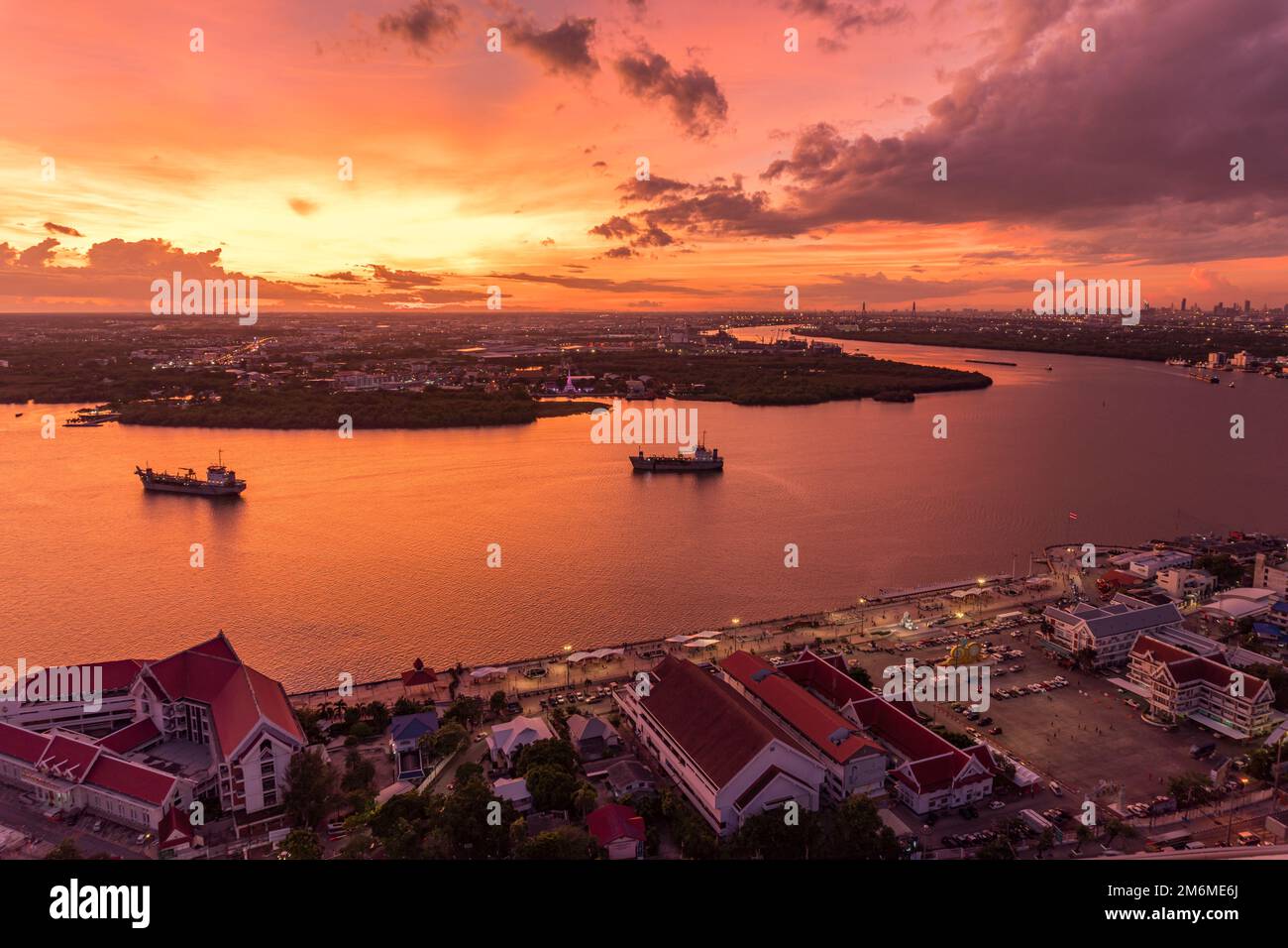 Vogelperspektive auf Samut Prakan, Thailand. Sonnenuntergang über dem Chao Phraya Fluss, orangefarbener Himmel. Stockfoto