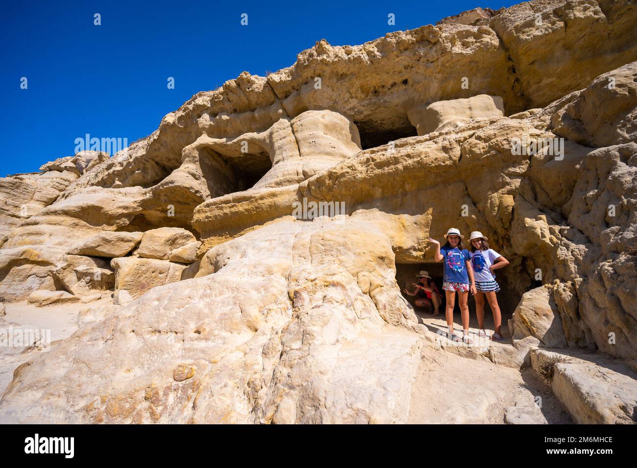 Der berühmte Matala Beach mit seinen Höhlen ist in den 70er Jahren für Hippies bekannt. Blick auf Felshöhlen, einst ein römischer Friedhof, am berühmten griechischen Strand Matala, Kreta, Griechenland. Stockfoto