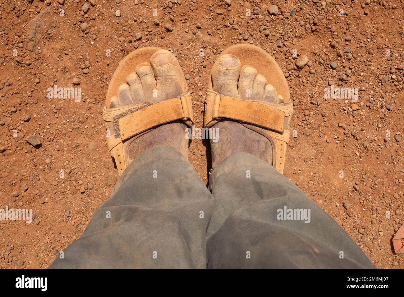 Der untere Teil eines Mannes, der schmutzige Schuhe in der Chalbi-Wüste in Kenia trägt Stockfoto