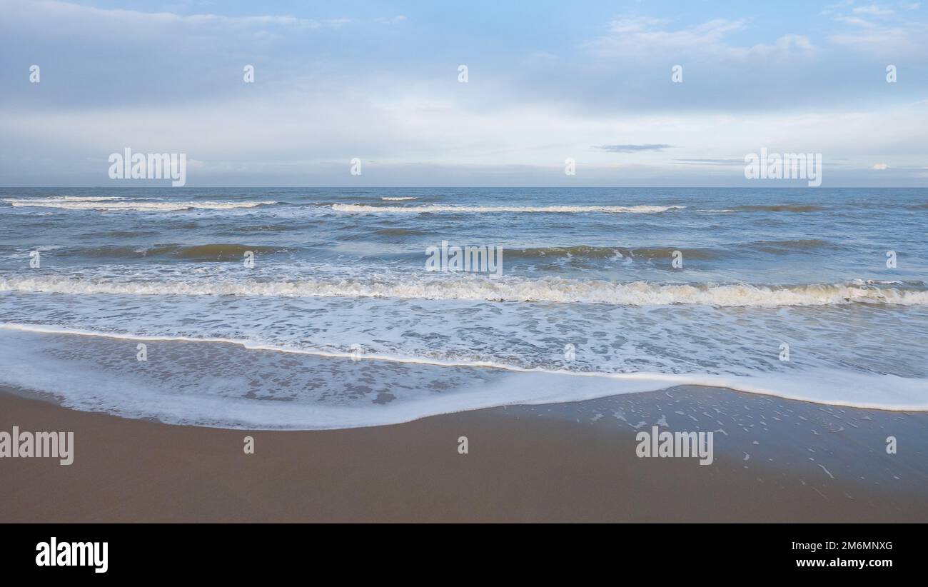 Panoramablick auf die Nordsee im Winter im schwachen Licht der Morgensonne mit teilweise bewölktem Himmel in Oostkapelle in den Niederlanden Stockfoto