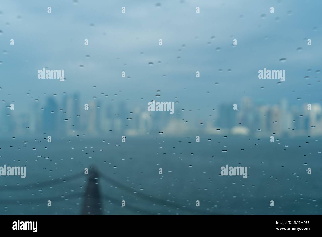 Regenschauer auf dem Glas des Autos mit modernem Hintergrund der Skyline von Doha. Selektiver Fokus Stockfoto