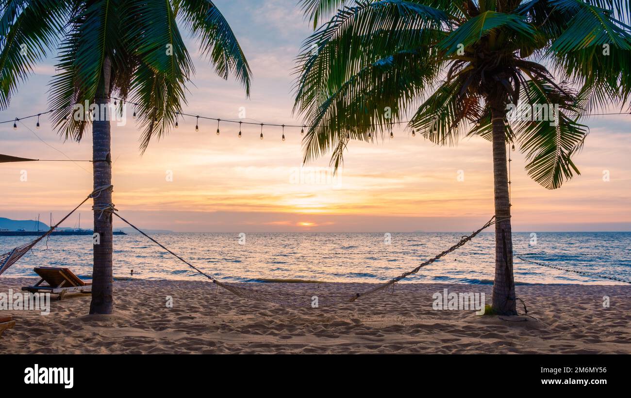 Sonnenuntergang am Strand von Na Jomtien Pattaya Thailand mit Palmen, einem weißen tropischen Strand bei Sonnenuntergang in Pattaya. Palmen am Strand. Stockfoto