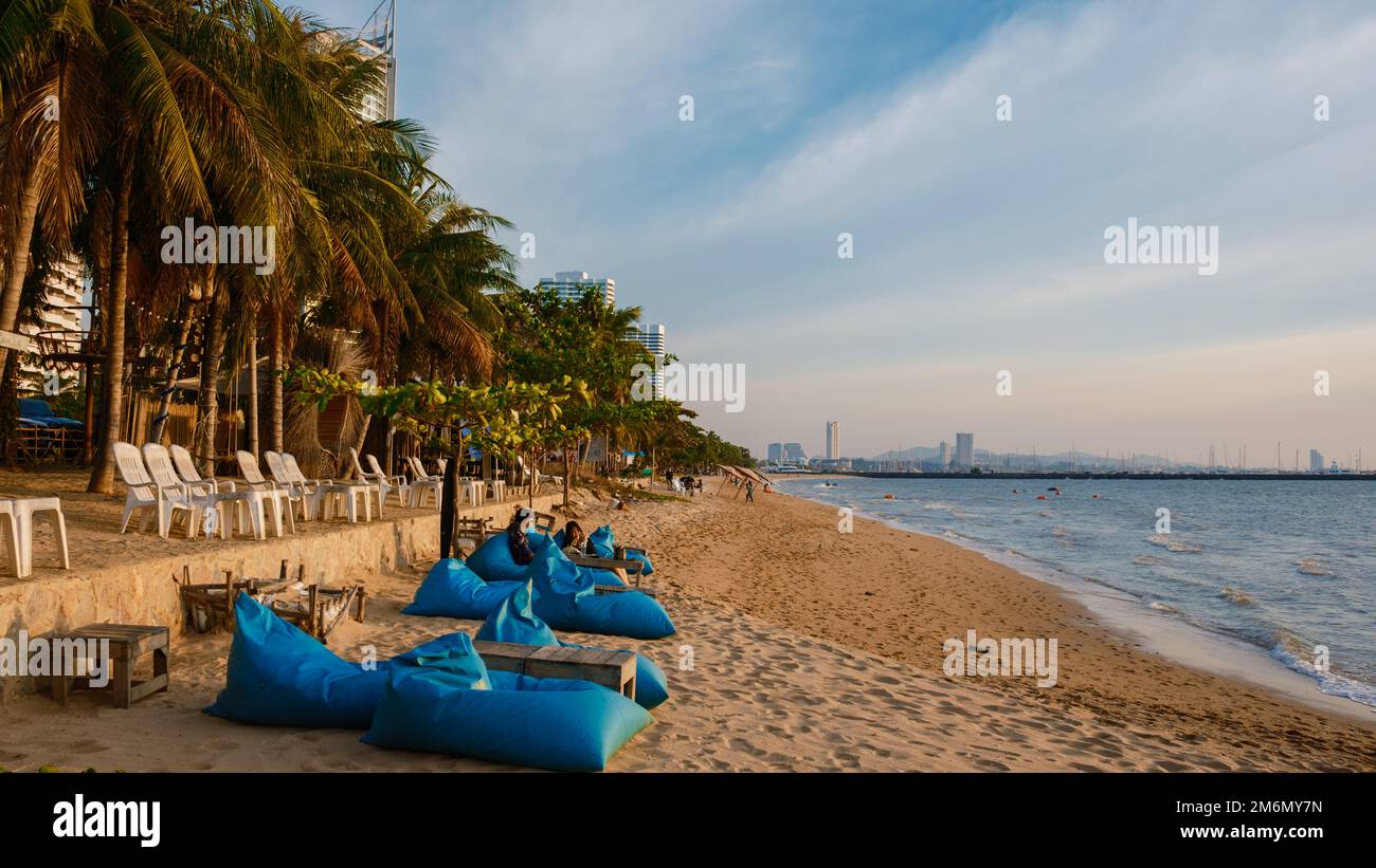 Najomtien Beach Pattaya Thailand 2022. Januar, Sonnenuntergang an einem tropischen Strand mit Palmen. Pattaya Thailand, Leute, die sich vor einem Restaurant am Strand entspannen Stockfoto