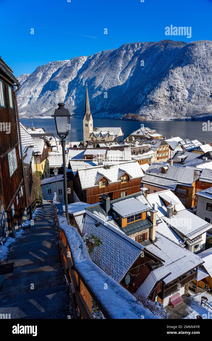 Wunderschönes Stadtbild der besonderen Stadt Hallstatt in Österreich Salzkammergut verschneite Winterberge und See und Kirche. Stockfoto