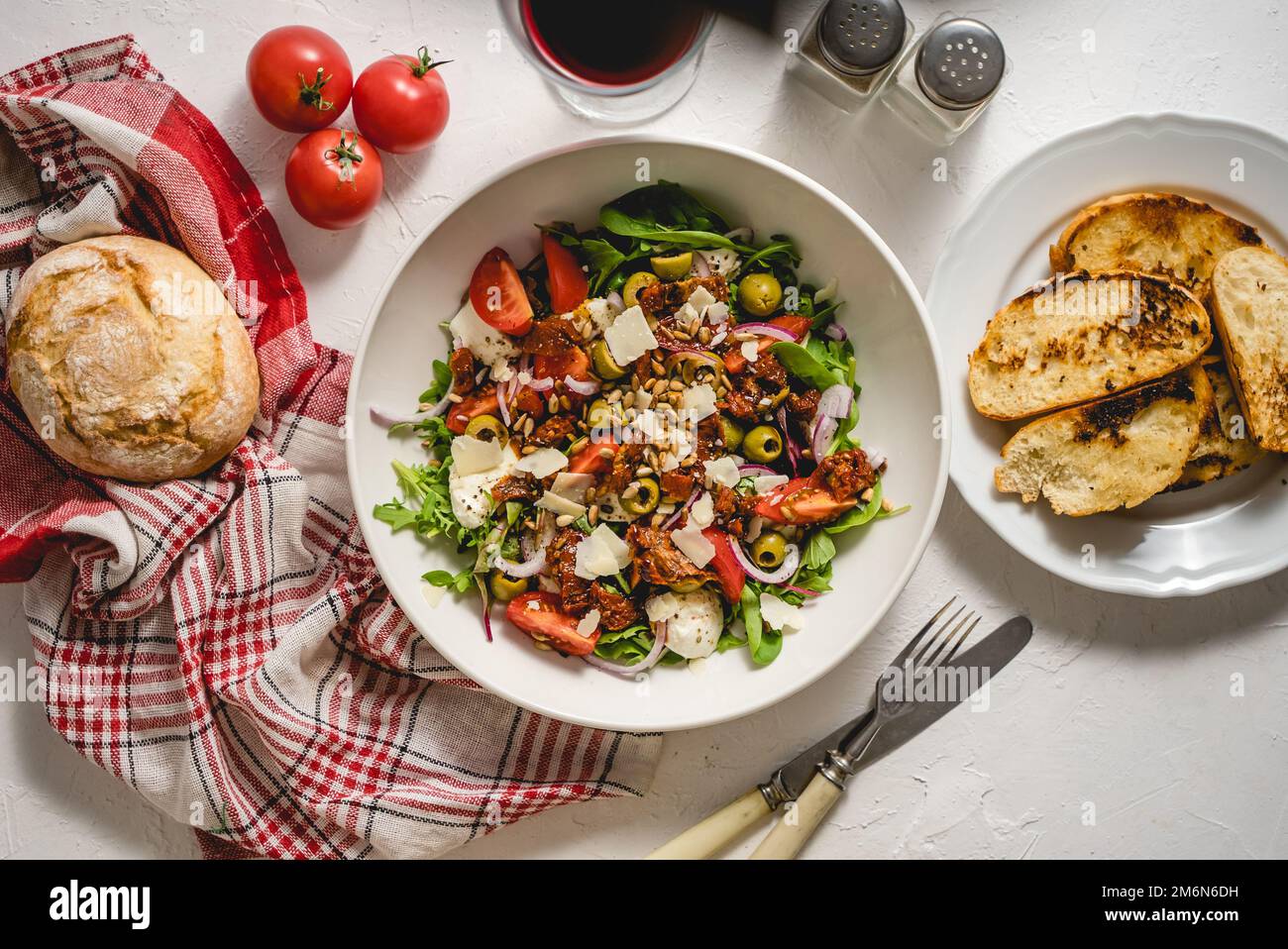 Leckerer Salat aus getrockneten Tomaten mit frischem Gemüsemix und Mozzarella-Käse, serviert mit Toast Stockfoto