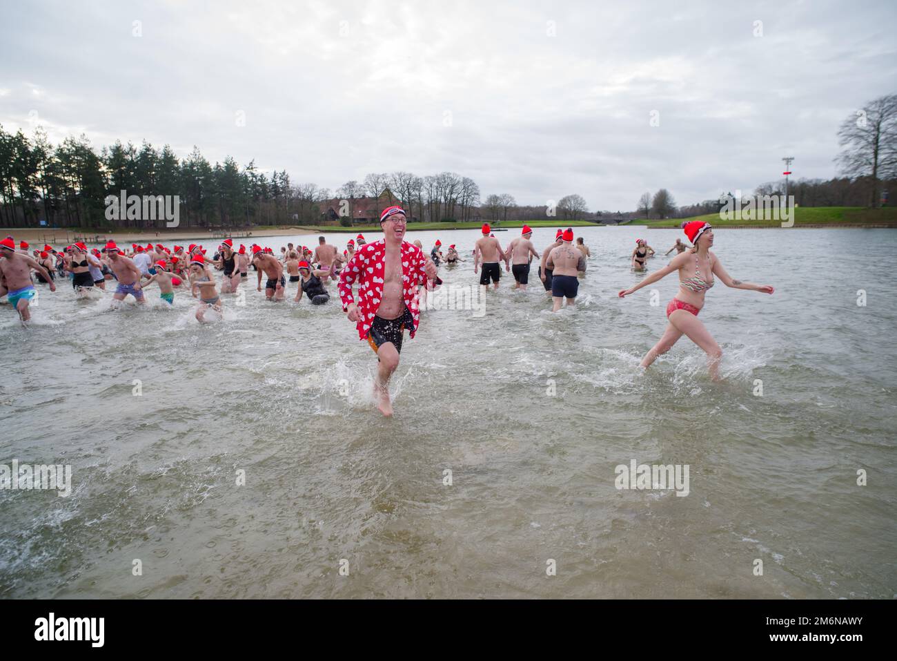 OLDENZAAL, NIEDERLANDE - 1. JANUAR 2023: Menschen, die beim traditionellen Neujahrsdiebstahl ins Wasser laufen Stockfoto