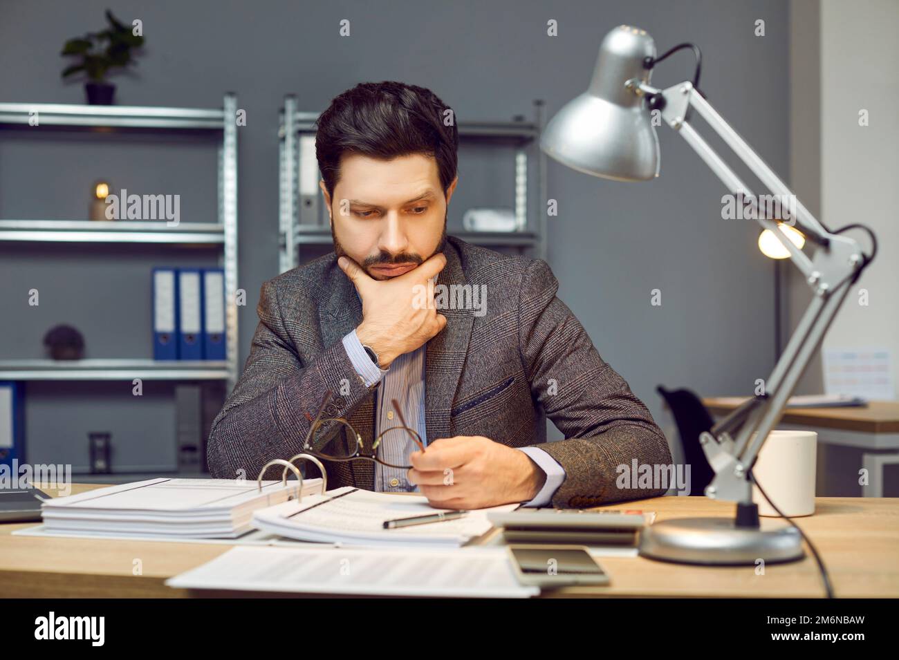 Junger Geschäftsmann, Rechnungsprüfer oder Finanzbuchhalter, der im Büro Papierkram erledigt Stockfoto