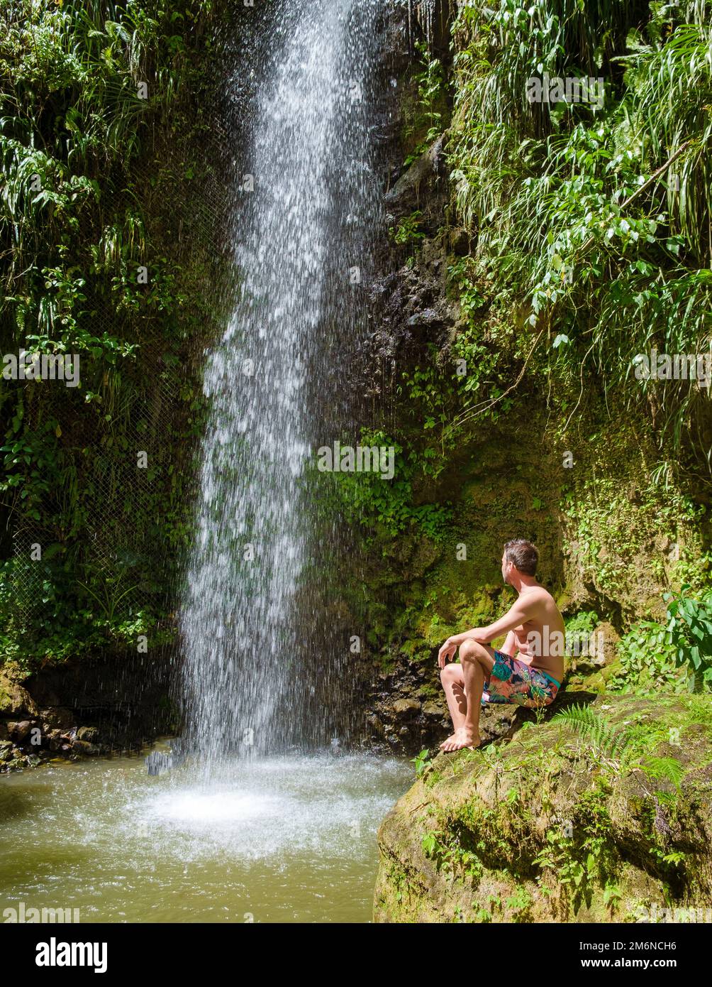 Junge Männer entspannen sich im Toraille Wasserfall St. Lucia. Dschungel-Wasserfall St. Lucia und Männer schwimmen Stockfoto