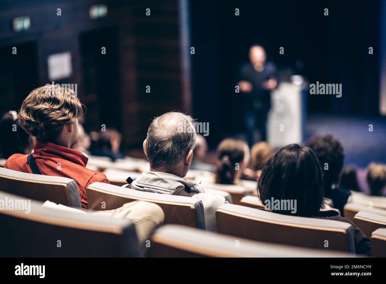 Referent, der bei einer Geschäftsveranstaltung im Konferenzsaal spricht. Rückansicht von nicht erkennbaren Personen im Konferenzsaal. Business und Entrepreneurship Konzept Stockfoto