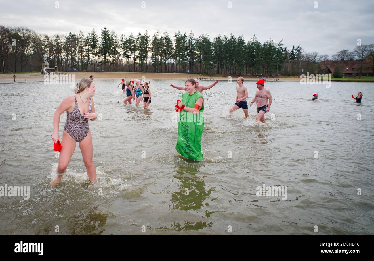 OLDENZAAL, NIEDERLANDE - 1. JANUAR 2023: Menschen, die beim traditionellen Neujahrsdiebstahl ins Wasser laufen Stockfoto