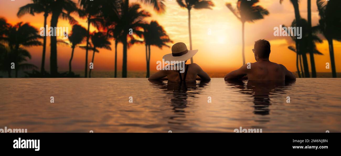 Ein Paar genießt den Sonnenuntergang vom Infinity-Pool im Tropical Island Resort Hotel. Romantischer Strandurlaub. Banner mit Kopierbereich Stockfoto