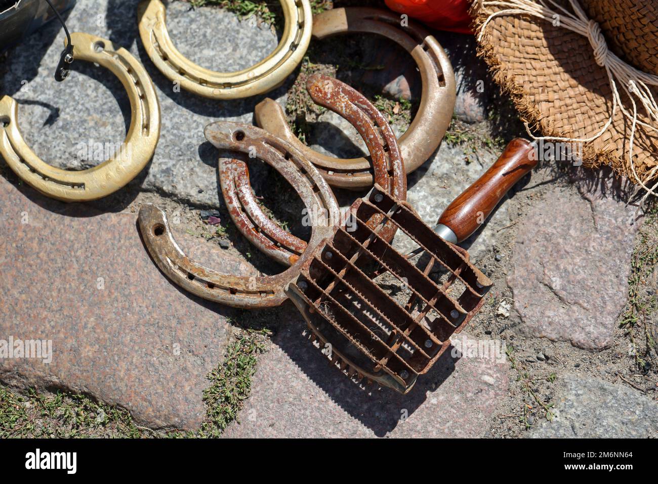 Mehrere Hufeisen und ein Werkzeug zum Pflegen und Pflegen von Pferden. Stockfoto