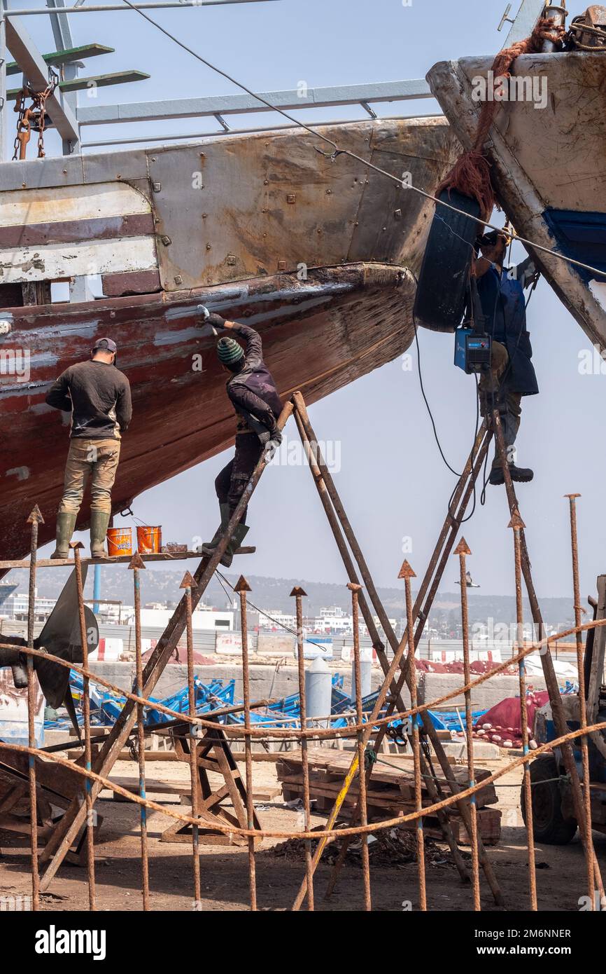 Boot im Trockendock zur Reparatur, mit Arbeitern auf Trittleitern Stockfoto