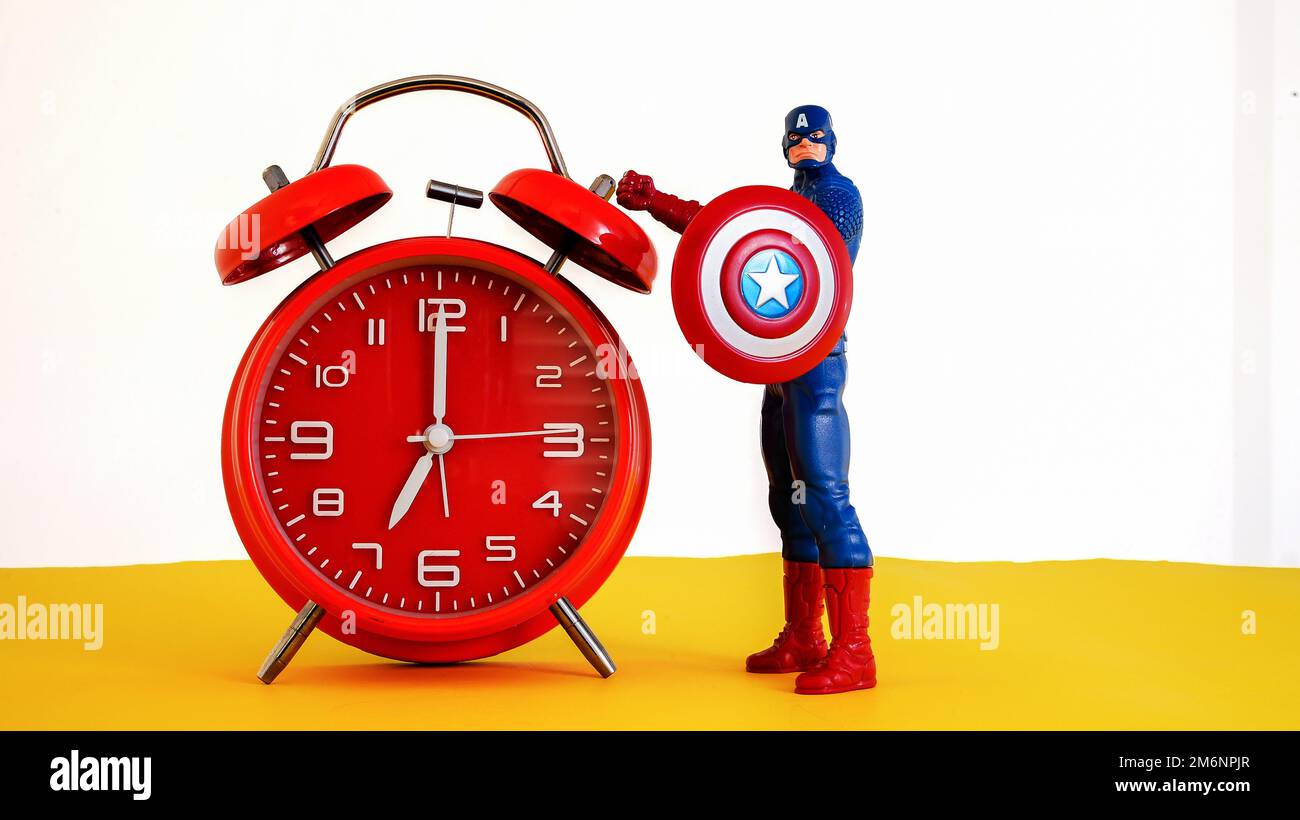 NORWALK, CT, USA - 4. JANUAR 2023: Rote Uhr mit Captain America auf gelbem und weißem Hintergrund Stockfoto