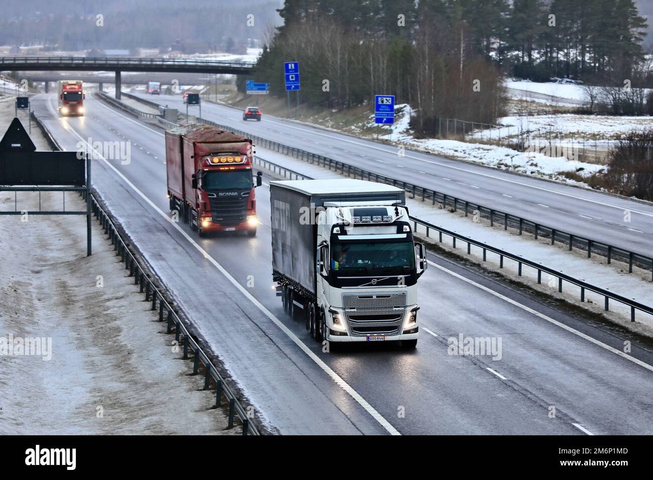 Gütertransporter im Autobahnverkehr an einem nebligen Winternachmittag. Salo, Finnland. 22. Dezember 2022. Stockfoto
