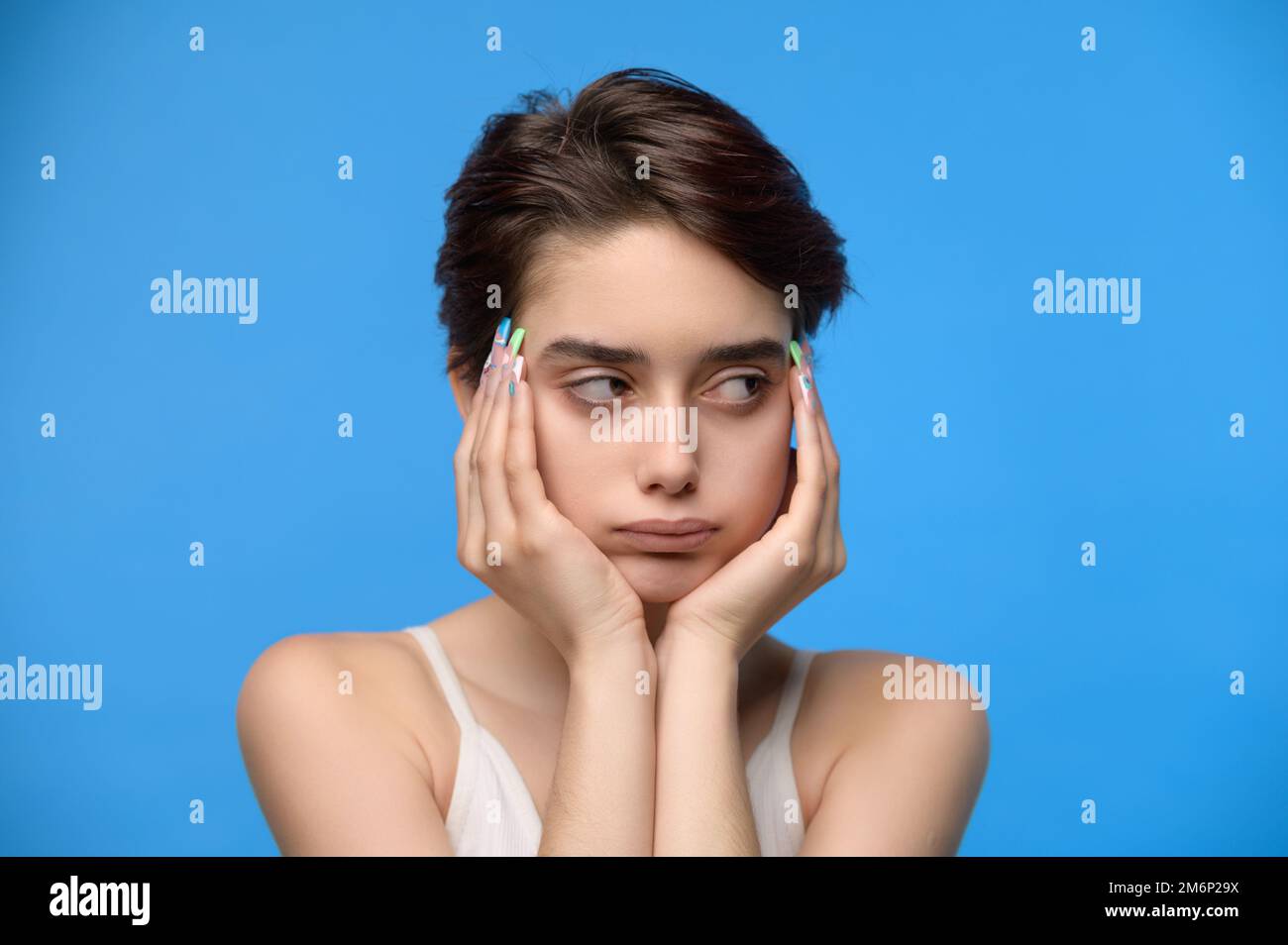 Trauriges, schmollendes Teenager-Mädchen auf blauem Hintergrund Stockfoto