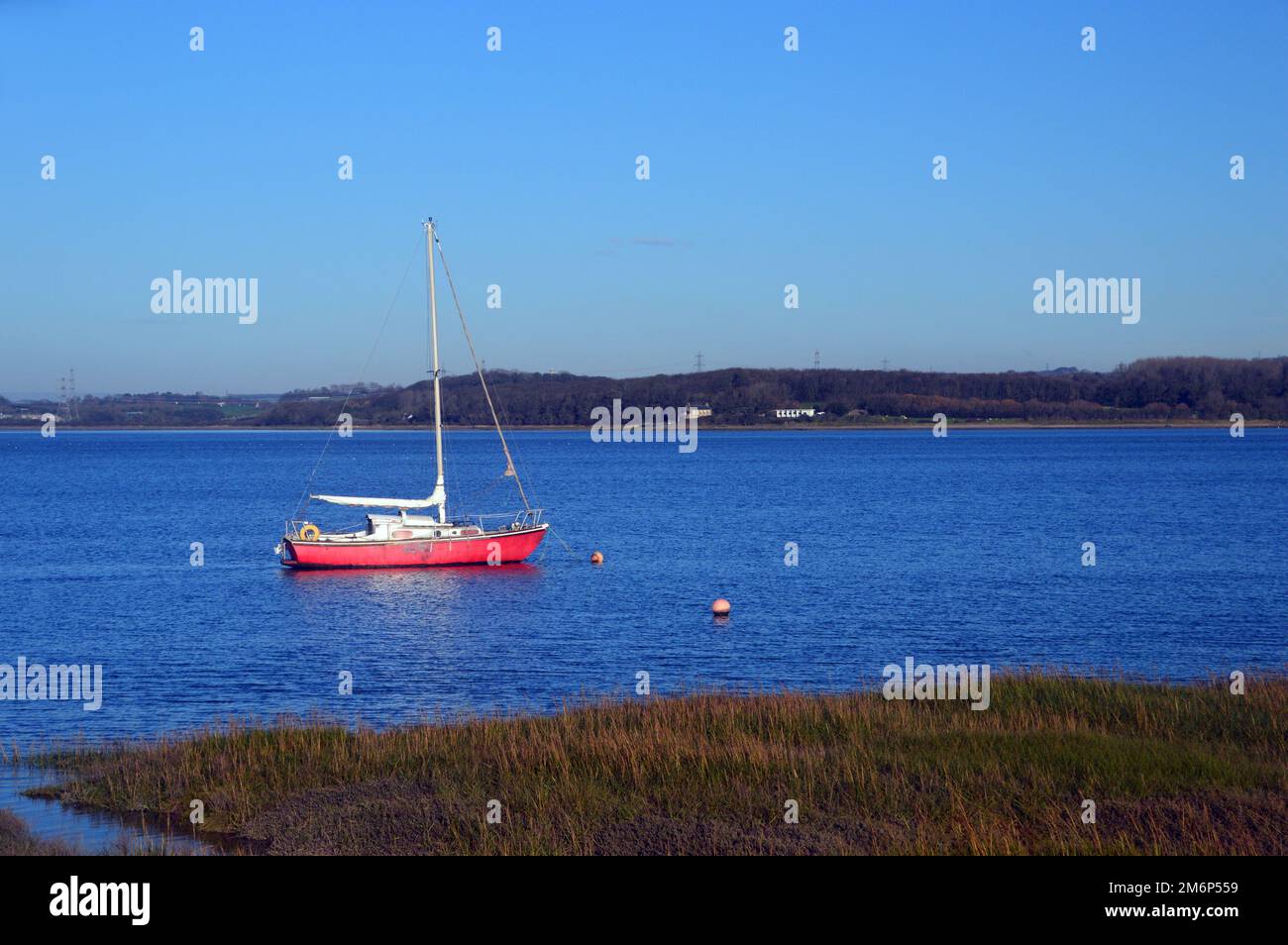 Kleines rotes Segelboot (Yacht) in der River Lune am Glasson Dock Marina in der Nähe von Lancaster in Lancashire, England, Großbritannien. Stockfoto