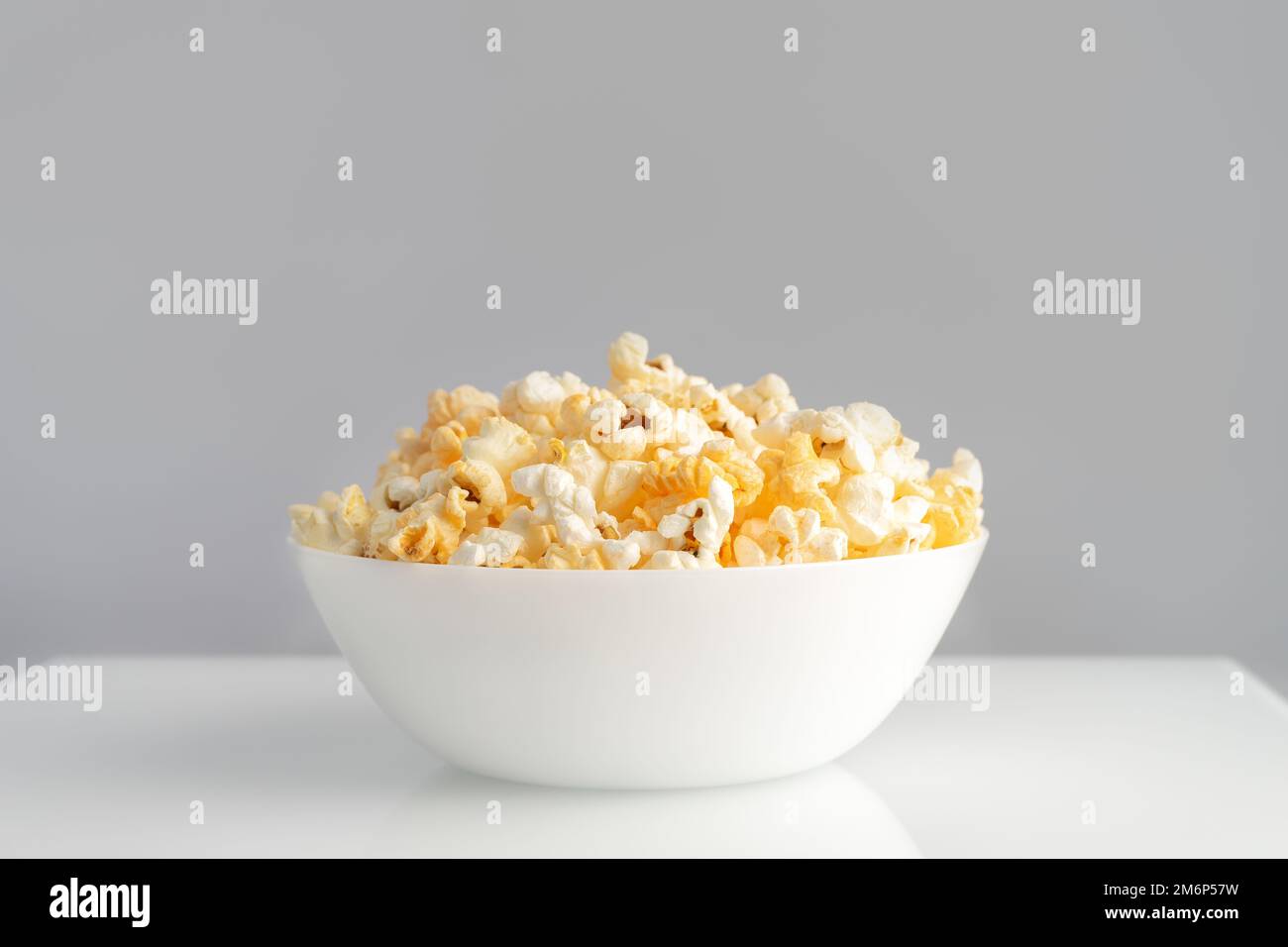 Leckeres Käse-Popcorn in der Schüssel isoliert auf weißem Hintergrund Nahaufnahme. Film-, Kino- und Unterhaltungskonzept. Stockfoto