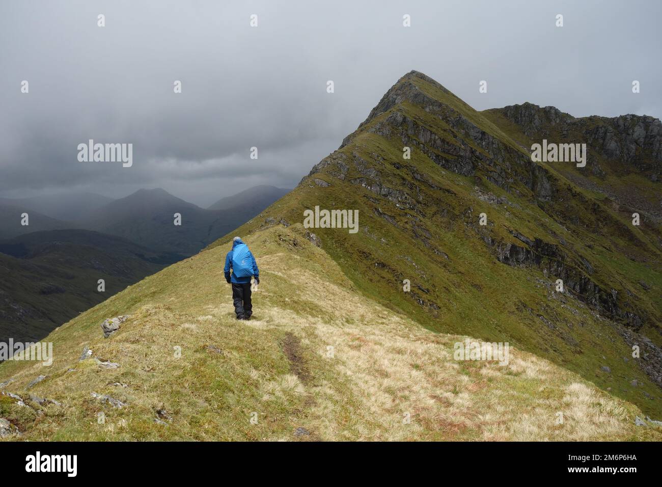 Ein Mann, der zur Arete geht, die zur Scottish Mountain Corbett 'Streap' in Gleann Dubh Lighe in der Nähe von Glenfinnan, Scottish Highlands, Schottland führt. Stockfoto