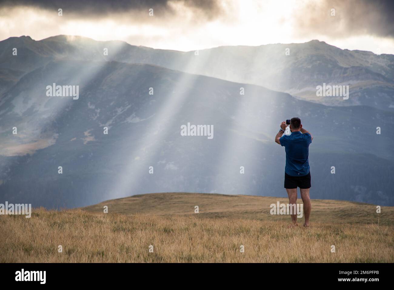 Ein Mann, der Fotos von himmlischen Lichtern in den Bergen macht Stockfoto