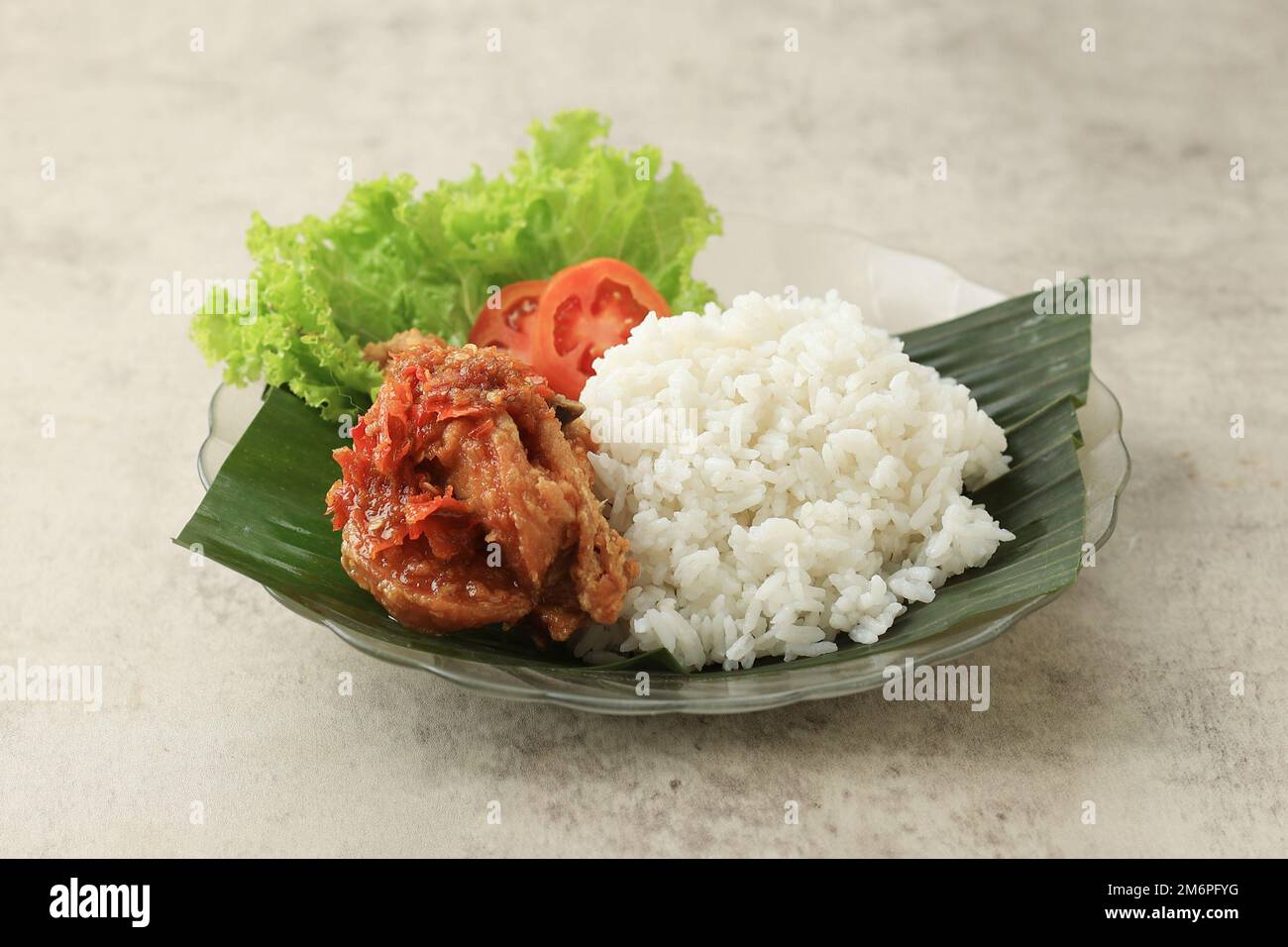 Ayam Penyet Geprek mit weißem Reis. Gebratenes Hähnchen mit scharfer Chilisauce, beliebtes indonesisches Essen Stockfoto