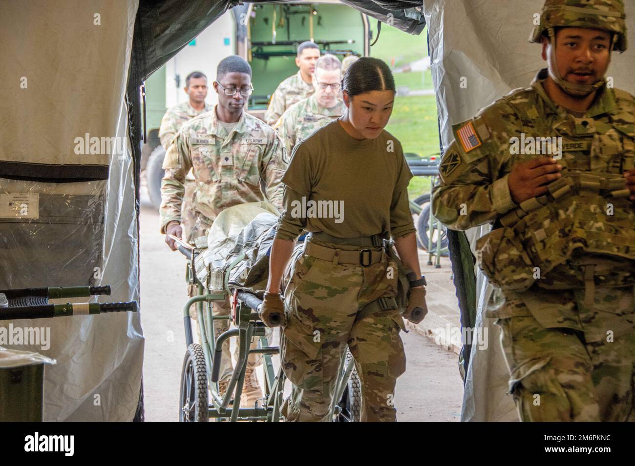 USA Armeesoldaten mit der 30. Medizinischen Brigade bringen einen Patienten in diese Simulation in die Notaufnahme des Feldlazaretts auf dem Flugplatz im Manöver Trainingsbereich. Die Übung ist Teil des Defender 22. DEFENDER-Europe ist ein jährliches großes US-Unternehmen Von der Armee geführte, multinationale, gemeinsame Übung, die darauf abzielt, Bereitschaft und Interoperabilität zwischen US-, NATO- und Partnermilitarien zu schaffen. Baumholder, Deutschland, 03. Mai 2022. Stockfoto