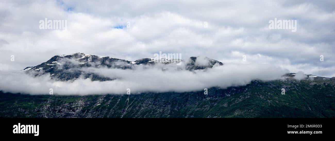Wolkenschleier über den Bergen in Hardangerfjord, Norwegen Stockfoto