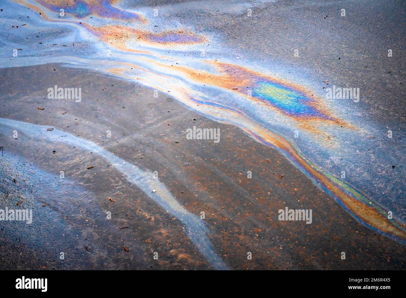 Ölflecken durch Undichtigkeiten im Fahrzeugmotor. Öl nach Regen macht Flecken mit