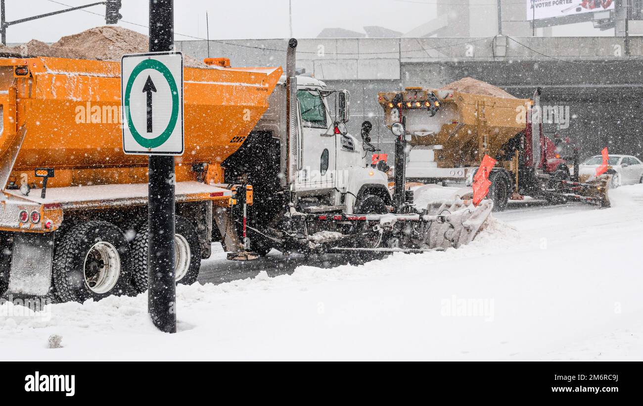Schneepflug-Truck in der Stadt. Winterfahrzeug. Schneeräumung auf der Straße. Schneeräumung auf der Straße. LKW, der Salz einbringt. Zwei Schneepflüge, die Schnee entfernen. Stockfoto