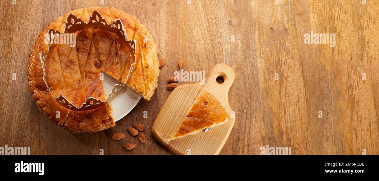 King Cake oder Galette des rois auf Französisch. Epiphanienkuchen mit goldener Papierkrone Stockfoto