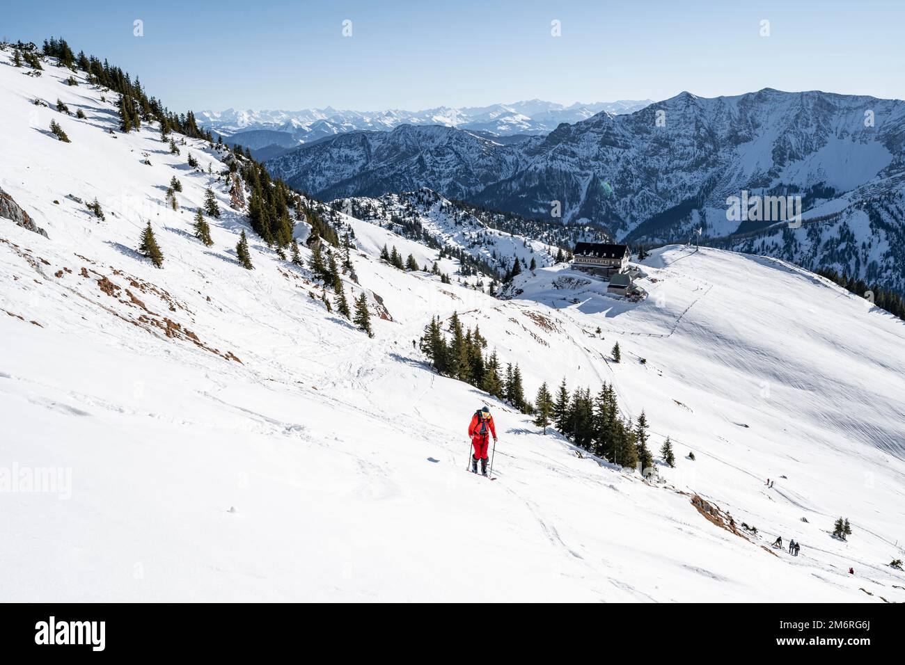 Skitouristen auf dem Rotwand, hinter der Berghütte Rotwandhaus mit Bergpanorama, im Winter Mangfall, Bayern, Deutschland Stockfoto