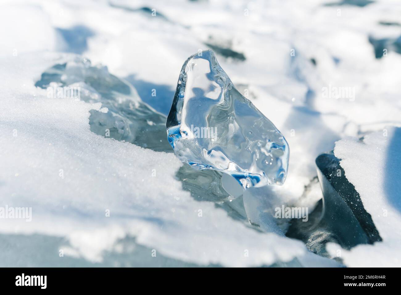 Eisstücke liegen auf dem idealen glatten Eis von baikal mit Eishummocks am Horizont Stockfoto