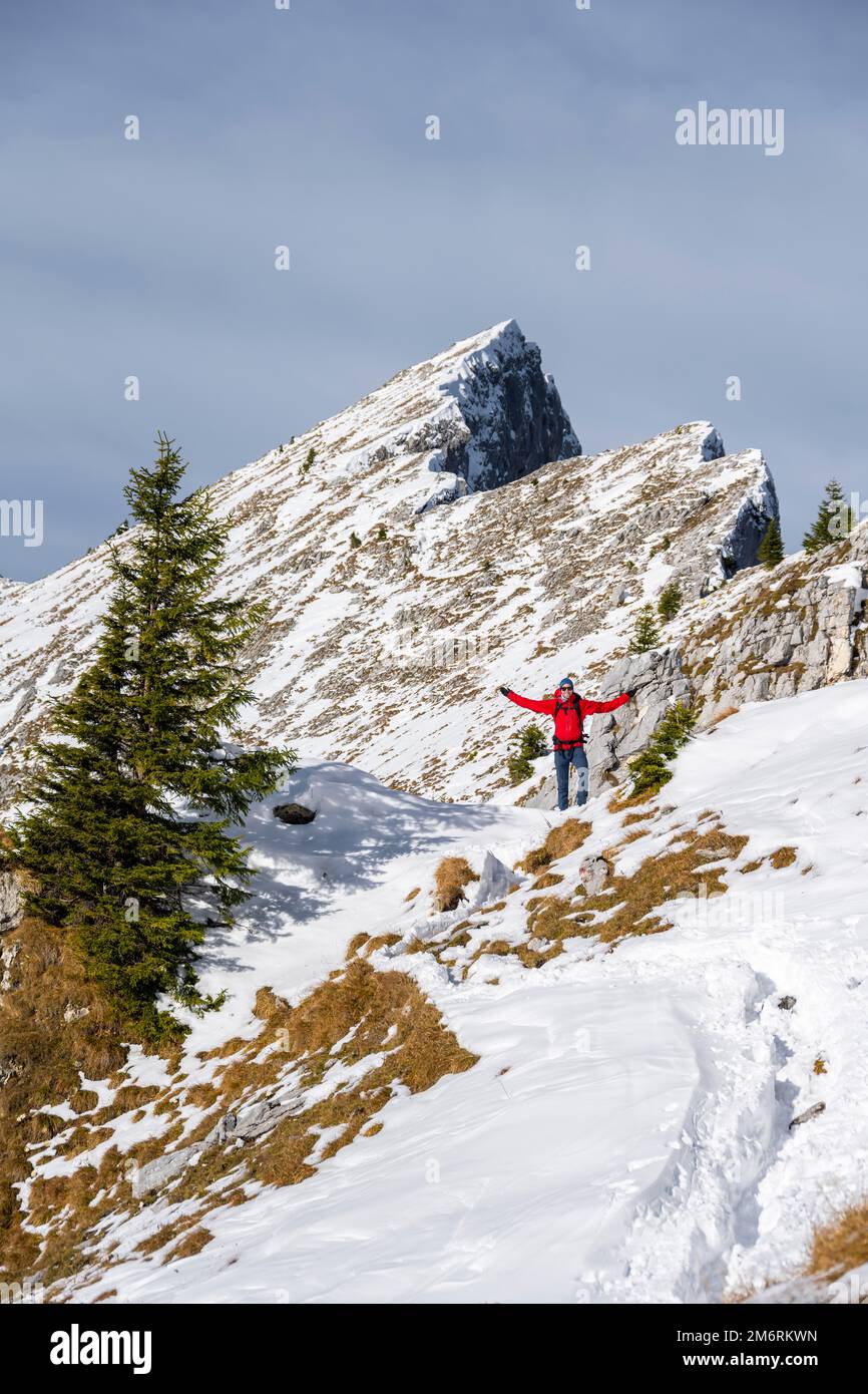 Glücklicher Wanderer, der seine Arme in der Luft streckt, Wanderweg im Winter, Pfad zur Ammergauer Hochplatte, Ammergau Alpen, Bayern, Deutschland Stockfoto