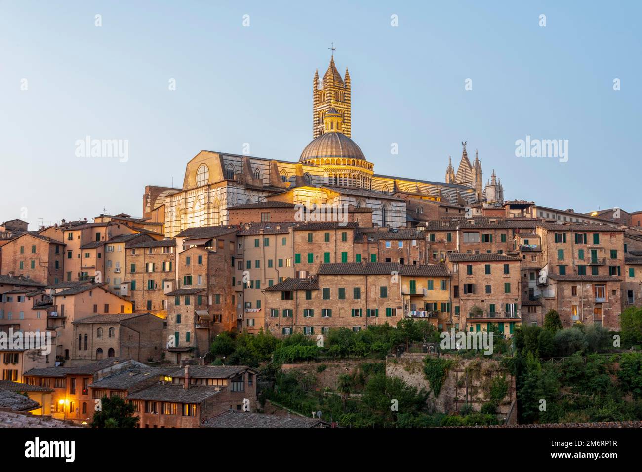 Kathedrale von Siena bei Sonnenaufgang, gotischer Architekturstil, vor ihr Häuser der Altstadt, Siena, Toskana, Italien Stockfoto