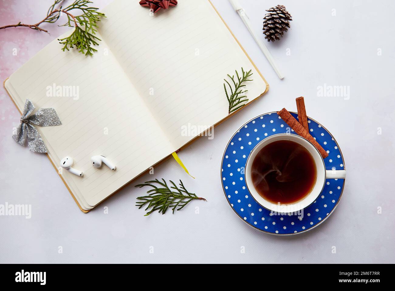 Weihnachtliches Modell leerer Notizblock mit ästhetischer Kaffeetasse, Donut, kabellosen Ohrhörern. Neujahrsvorsatz, Planung, Neubeginn und Liste der Ziele CO Stockfoto