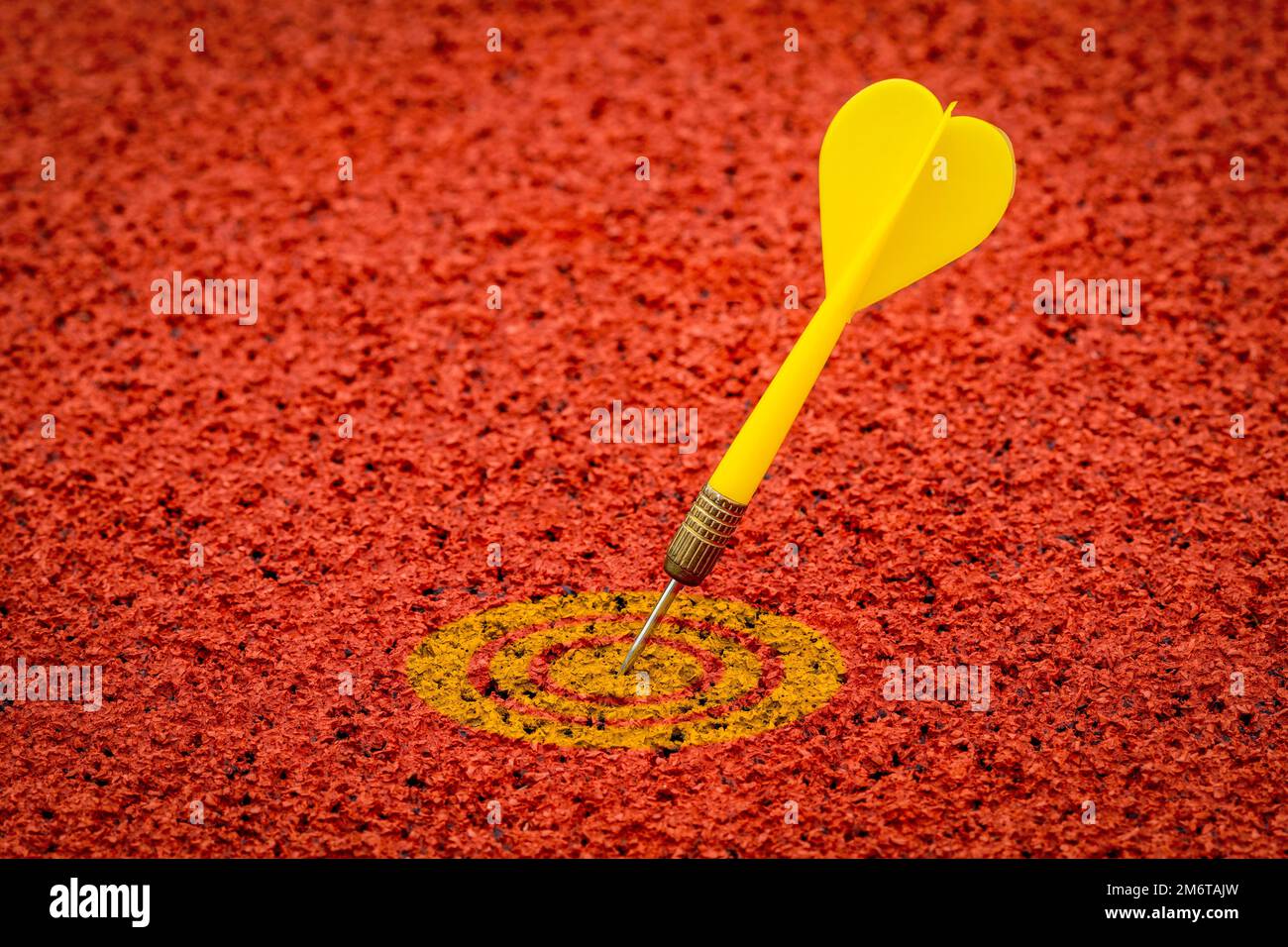 Der gelbe Pfeil trifft das gelbe Ziel auf dem gummierten Sportplatz Stockfoto