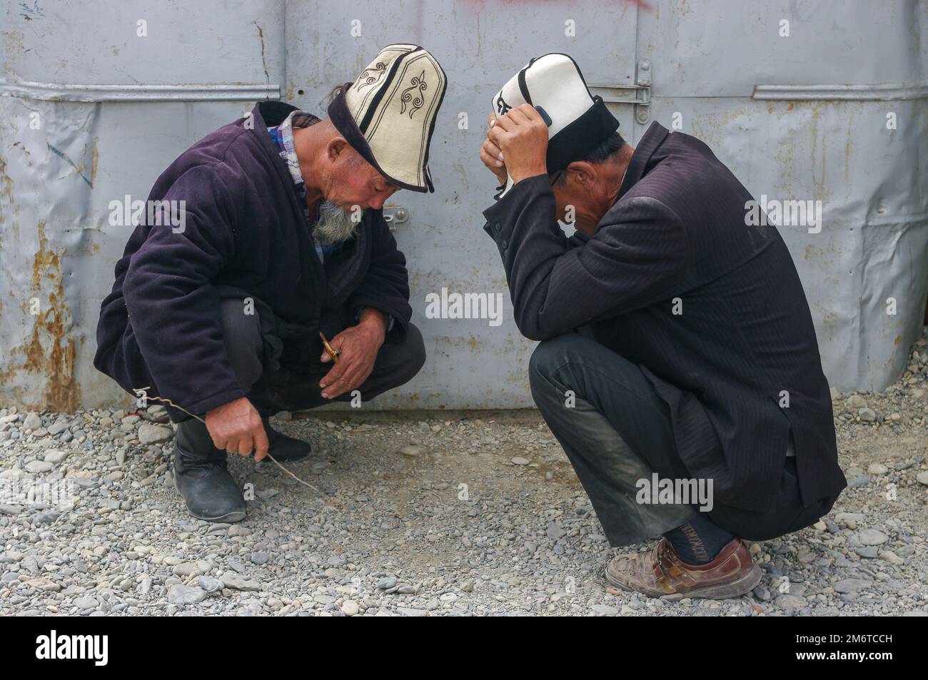 Murghab, Gorno-Badakshan, Tadschikistan - 07 30 2014 : zwei alte Männer mit traditionellem kirgisischen Kalpak haben sich auf dem Murghab-Markt mit einem Hut besetzt und unterhalten Stockfoto