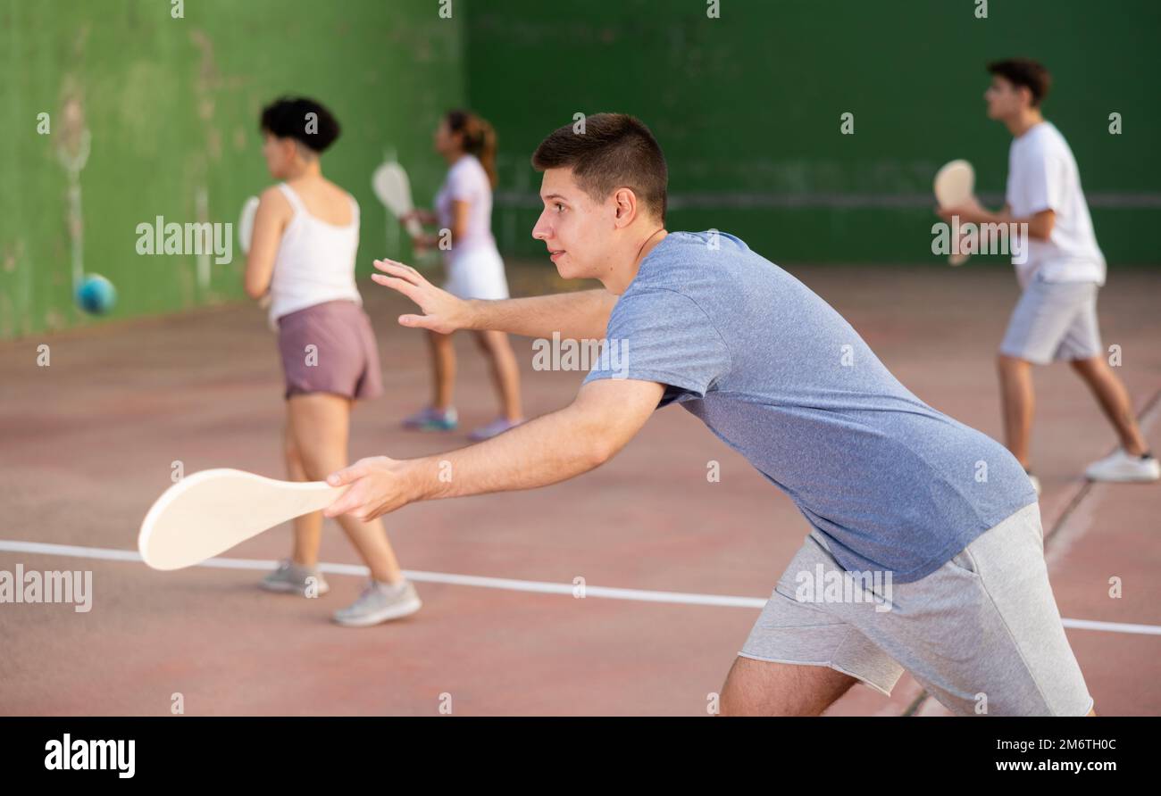 Junger Mann, der beim Pelota-Spiel im Freien Ball servierte Stockfoto