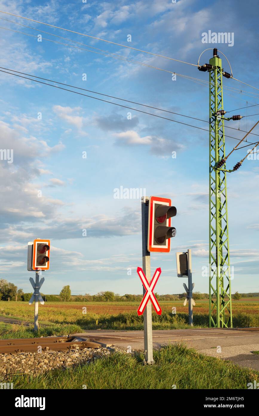 Eine Schranke und eine rote Ampel am Bahnübergang. Bahnhof. Stockfoto