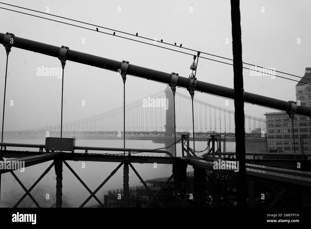 Über die Brooklyn Bridge im Nebel zu laufen und die Manhattan Bridge, NYC, zu sehen Stockfoto