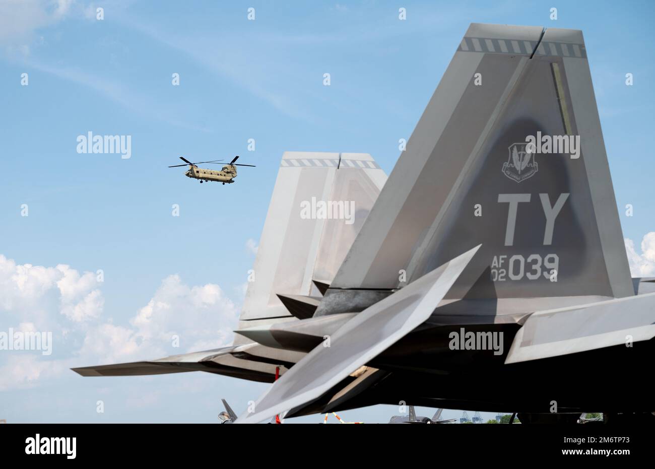 Ein Chinook der CH-47 schwebt hinter dem Schwanz eines F-22 Raptors, der dem 325. Kampfflügel, Eglin Luftwaffenstützpunkt, Florida, am Savannah Hilton Head International Airport, 5. Mai 2022 zugeteilt wurde. Der 325. Kampfflügel schickte mehr als 200 Mitarbeiter und 22 Flugzeuge, um an Sentry Savannah teilzunehmen, einer Übung, die vom Air Dominance Center der Air National Guard ausgerichtet wurde. Stockfoto