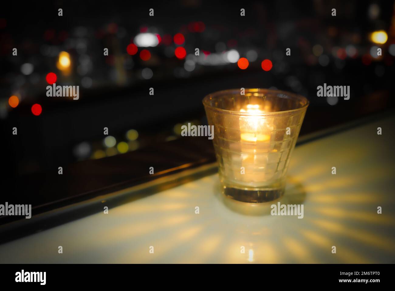 Stilvolle Kerze und Blick auf die Stadt bei Nacht Stockfoto
